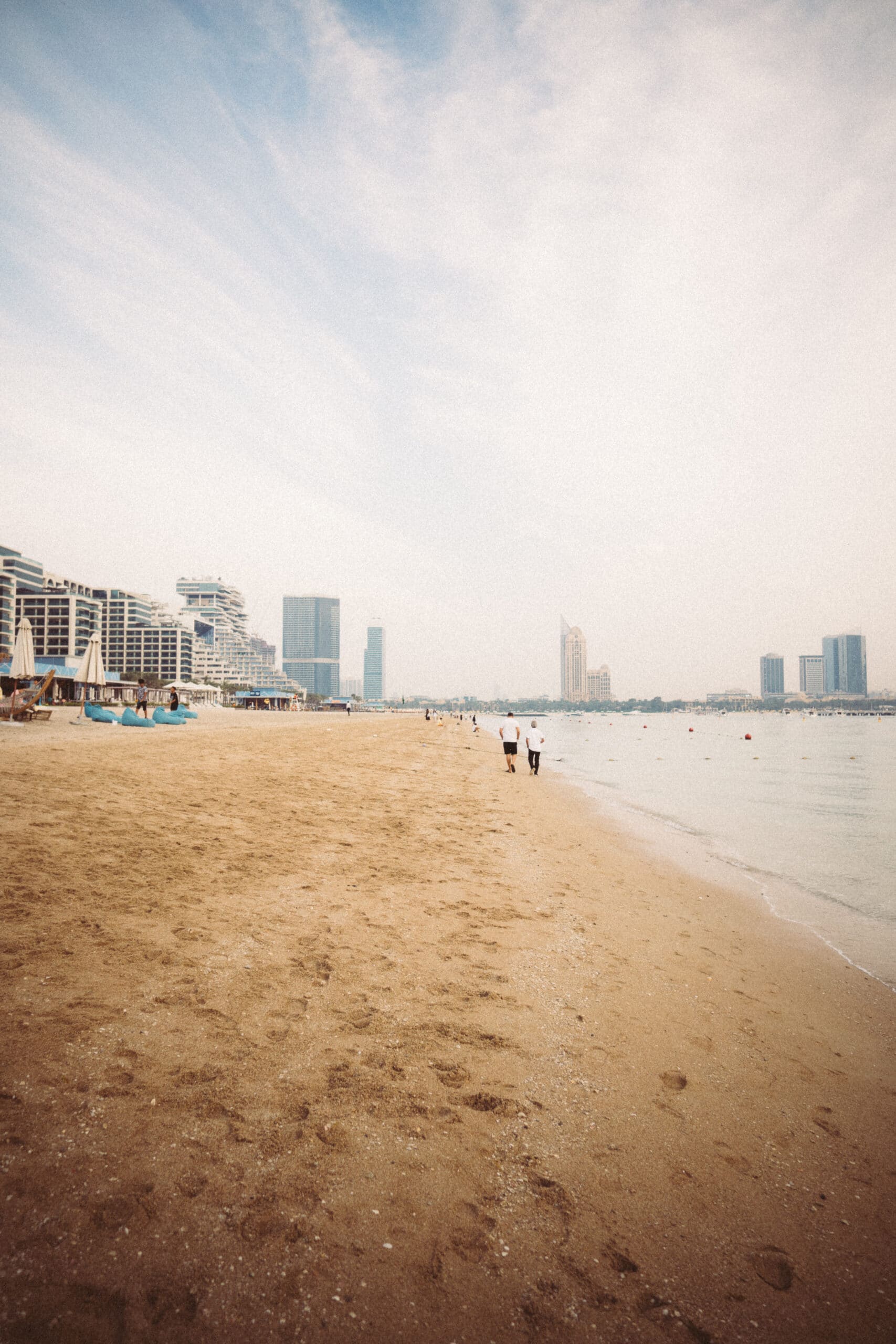 Plage paisible de Palm Jumeirah, avec une vue sur les gratte-ciels et les hôtels de luxe en bord de mer.