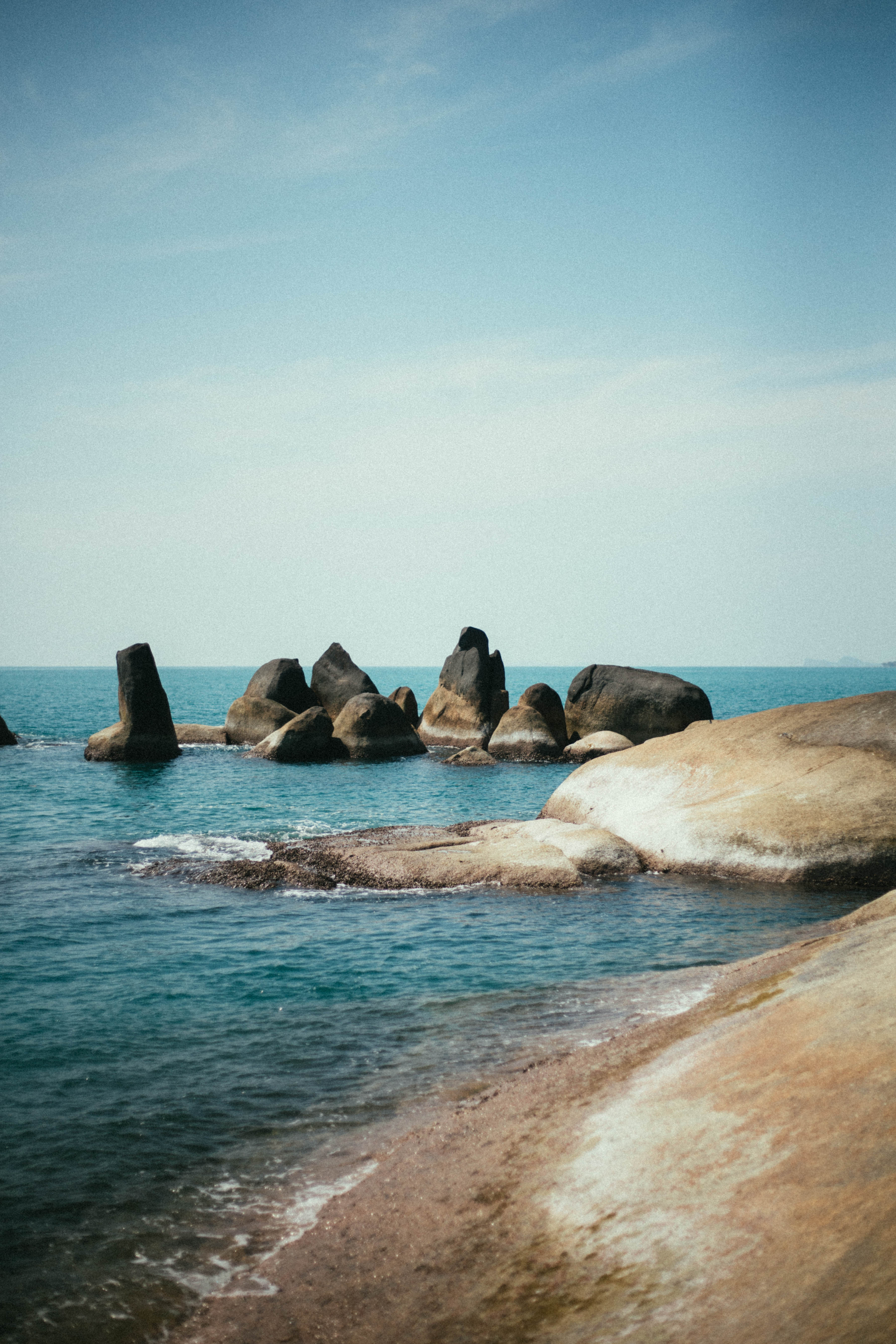 Les rochers de Hin Ta–Hin Yai dans la mer, vus depuis le littoral.