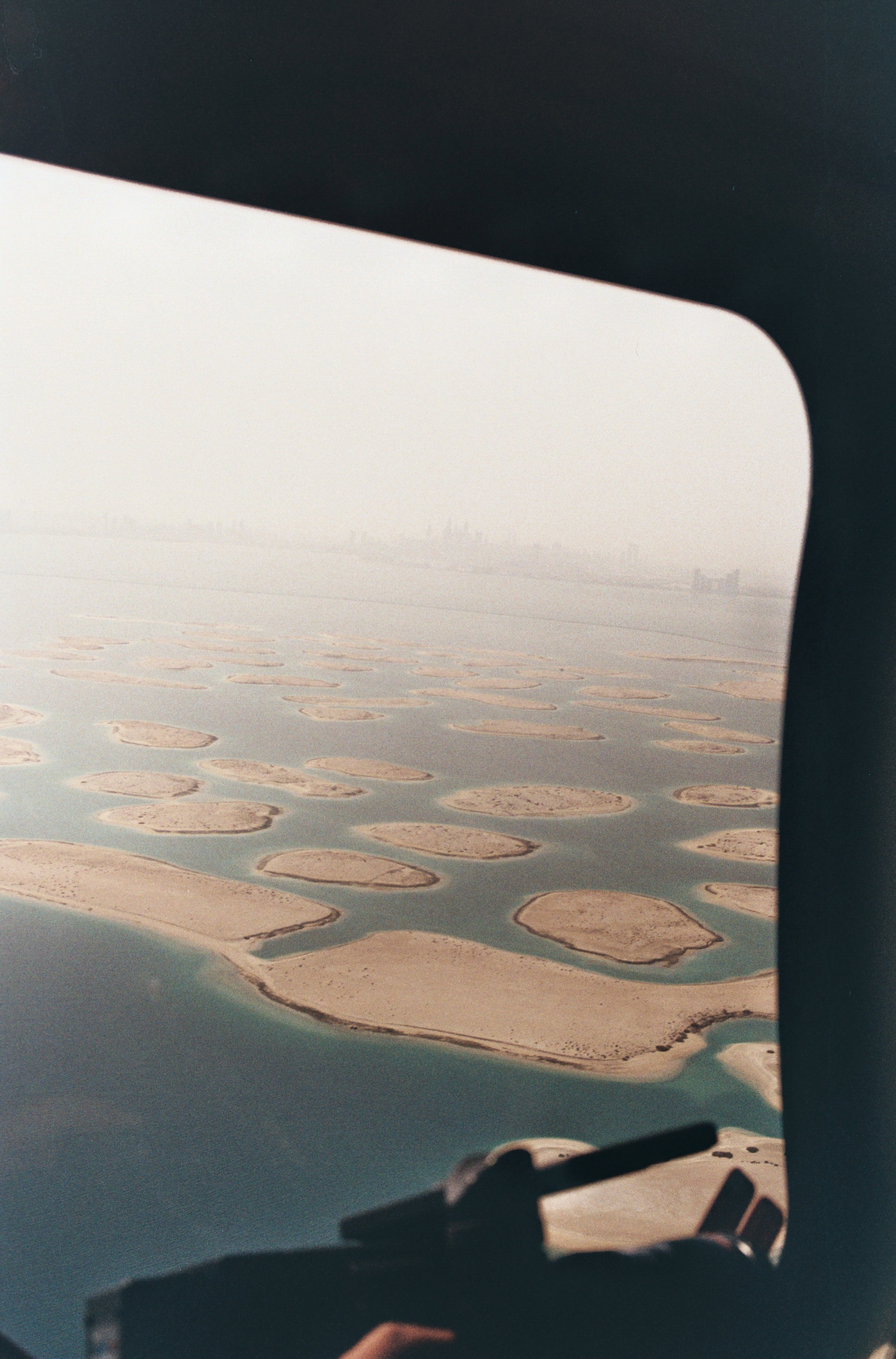 Îles artificielles et mer vues à travers le hublot d’un appareil.