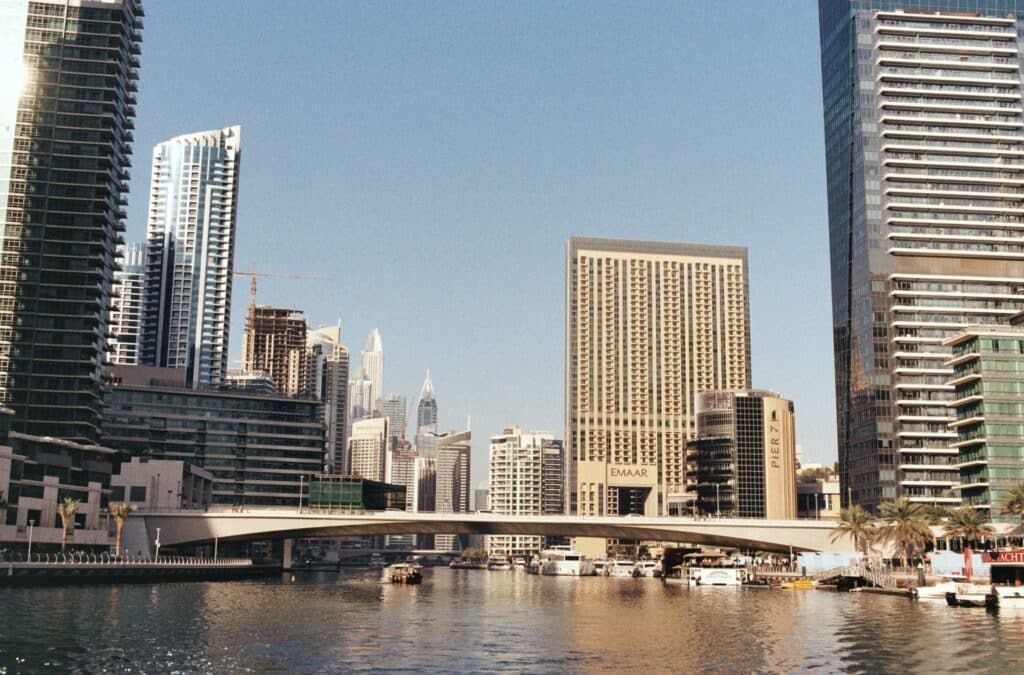 Vue sur les gratte-ciels et le canal de Dubai Marina, avec le pont et des yachts amarrés.