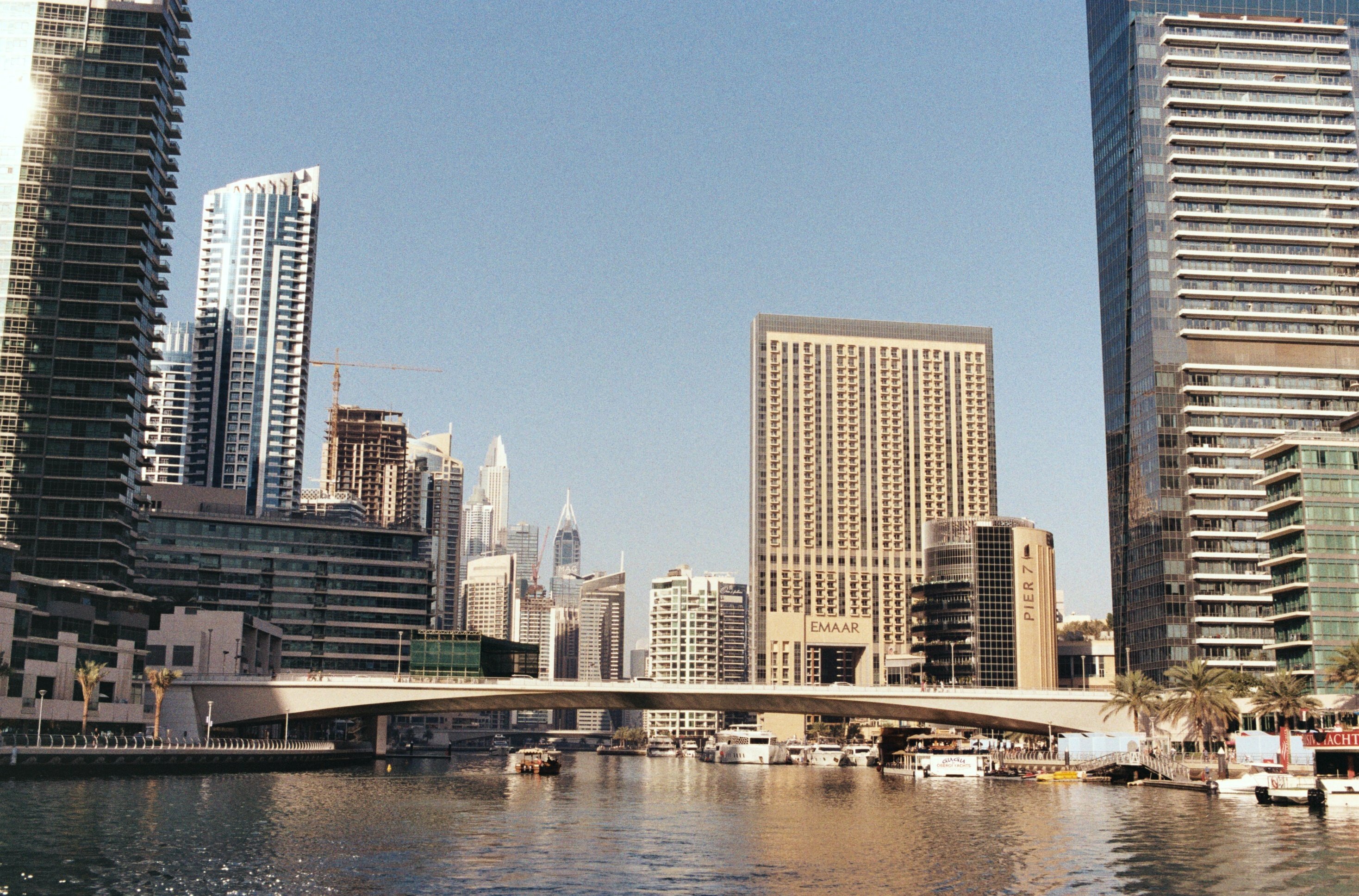 Canal de Dubai Marina, tours, passerelle et bateaux amarrés.