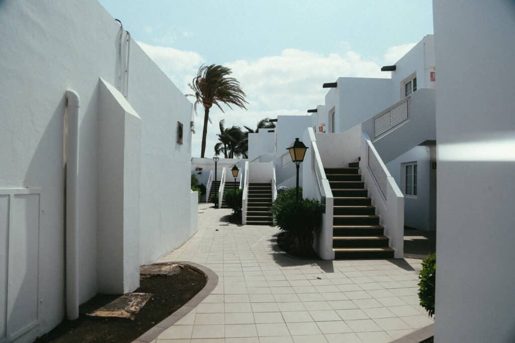 Architecture blanche typique de Lanzarote avec escaliers et palmiers.