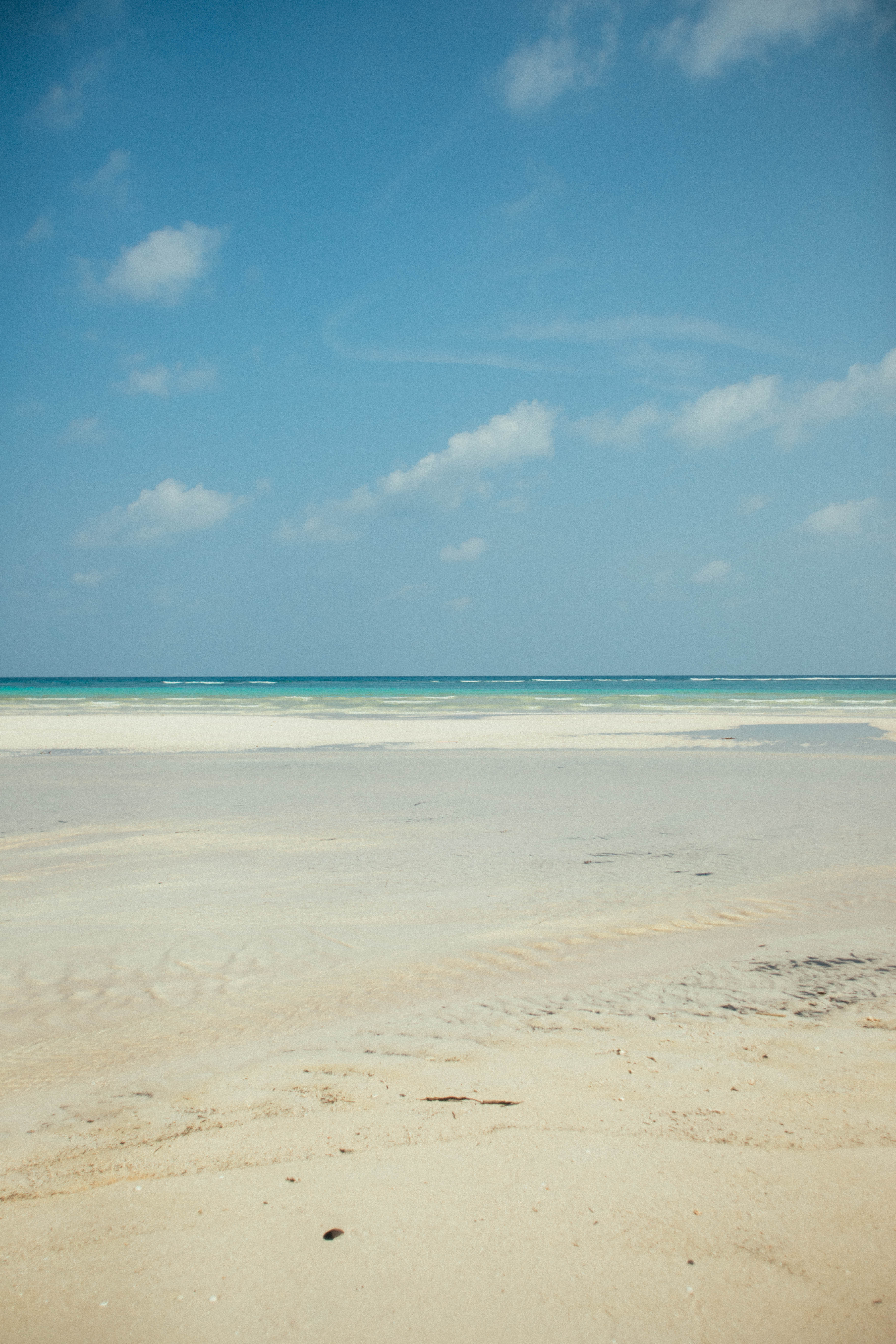Une large étendue de sable et d’eau peu profonde sur une plage de Koh Samui.