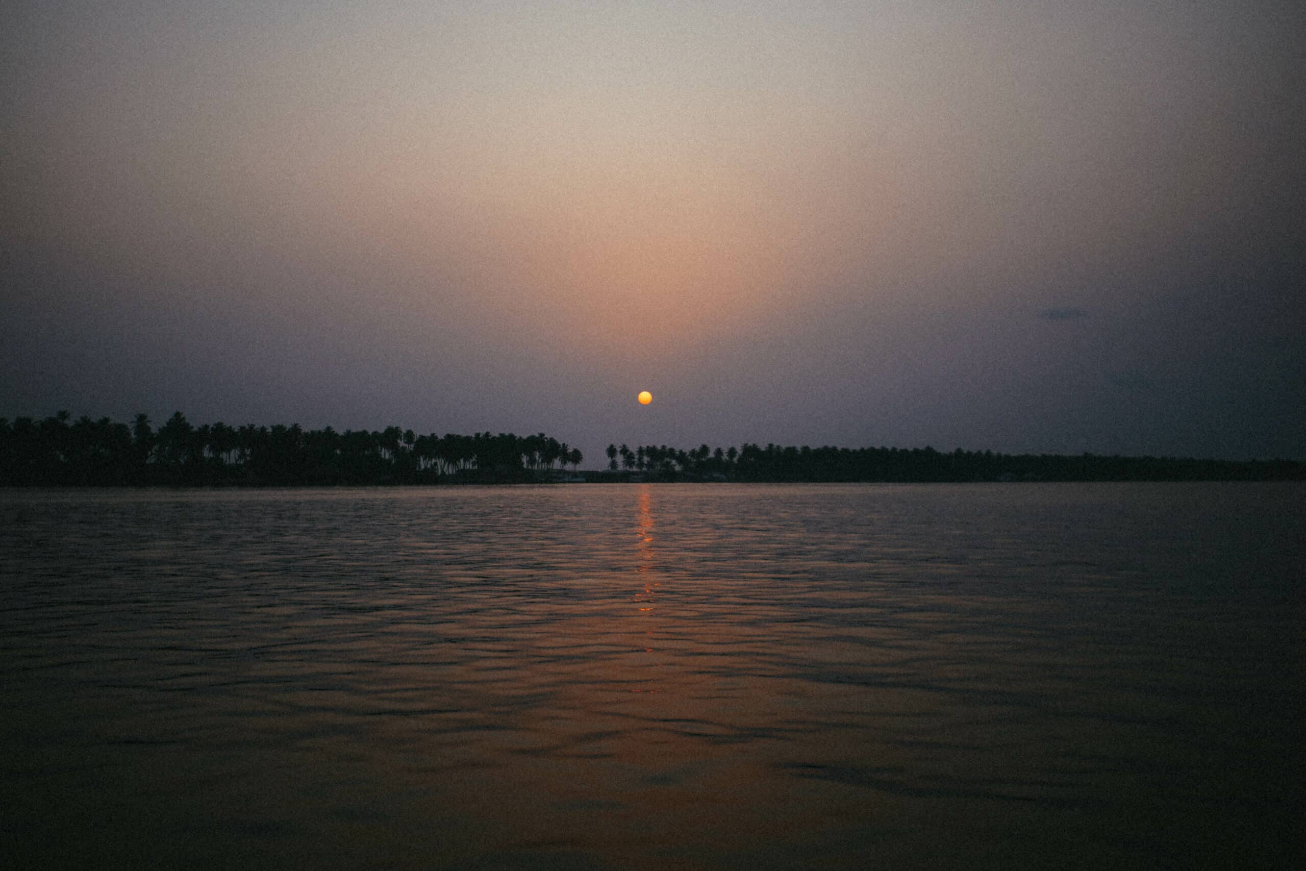 Soleil couchant reflété sur l’eau en Côte d’Ivoire.