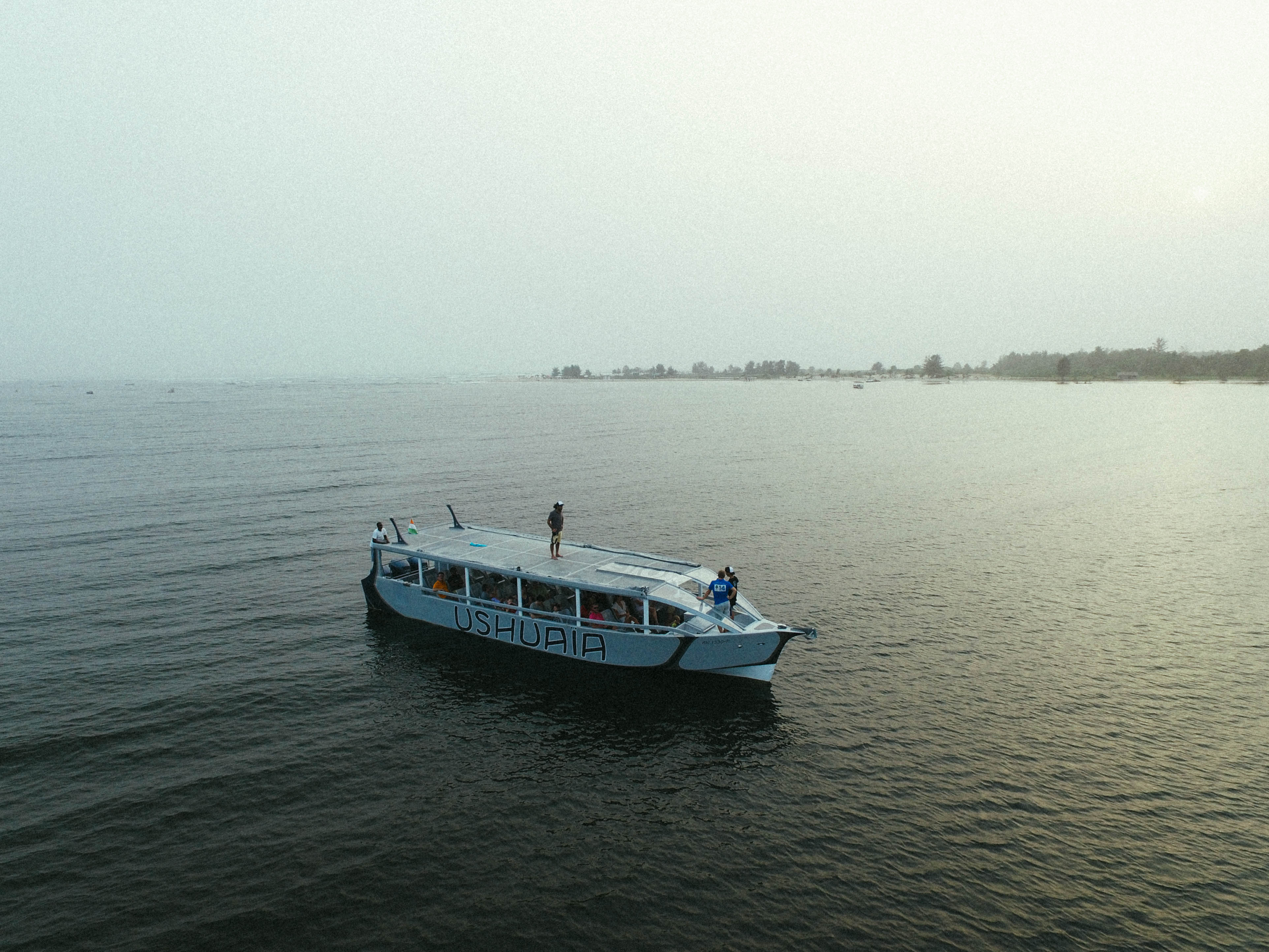 Bateau sur une étendue d’eau calme, face à une rive lointaine.