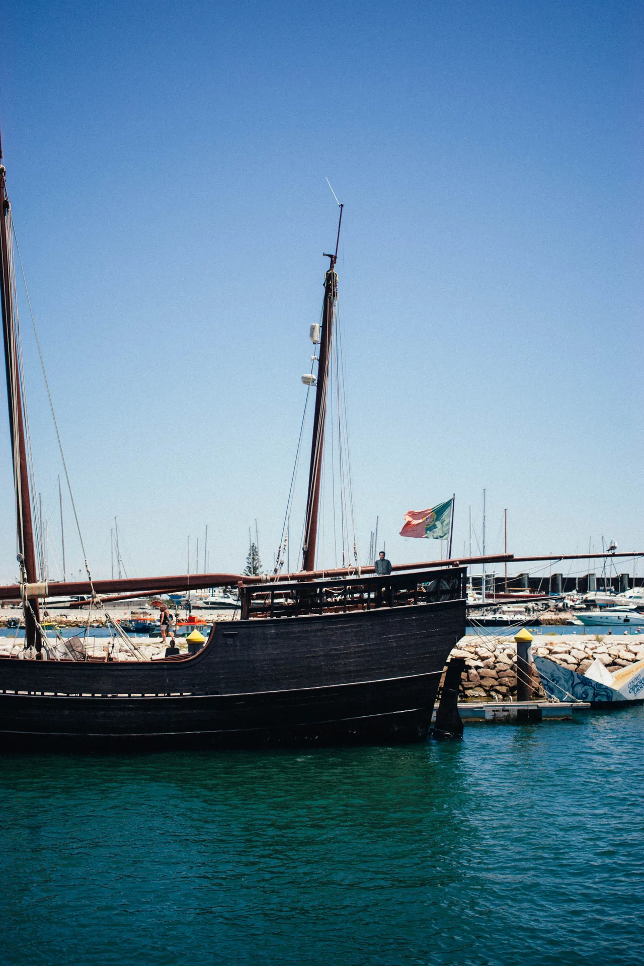 Bateau à grands mâts amarré à Lagos, sous un ciel bleu.
