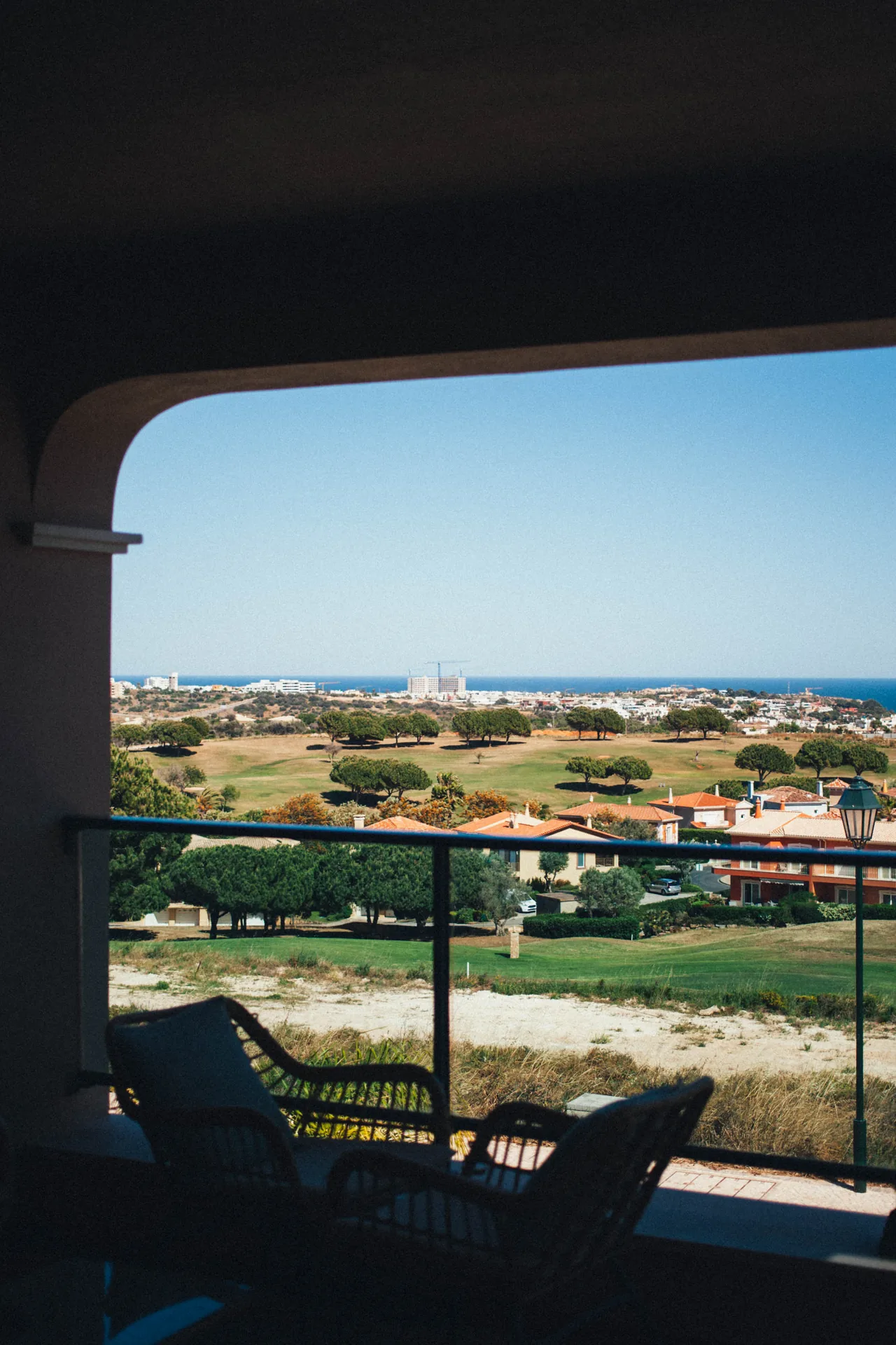 Vue depuis la terrasse couverte de la maison louée, avec table et chaises.