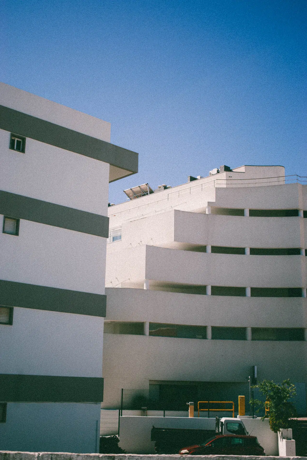 Architecture blanche avec des rampes courbes et des vitrages verts à Lagos.