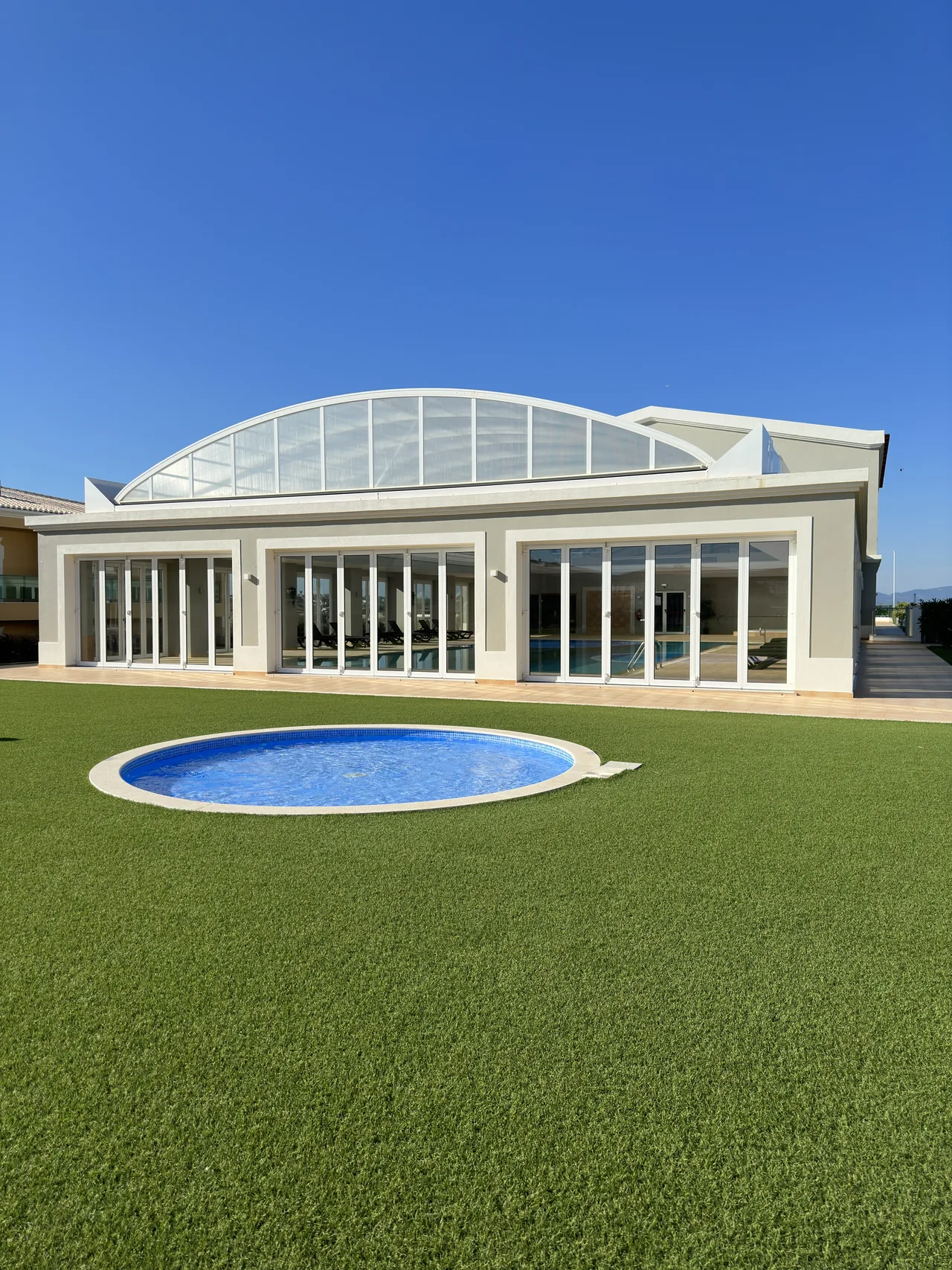 Centre de loisirs dans le secteur de Boavista à Lagos, avec une toiture vitrée et un bassin extérieur.